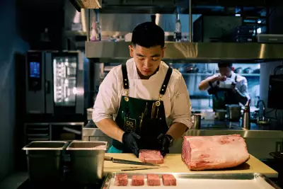 Akin Toronto | Chef Eric Chong slices meat in the kitchen