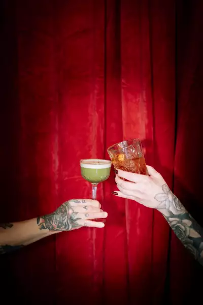 Ayla Upstairs | Cocktails clink in front of a red curtain at Ayla Upstairs