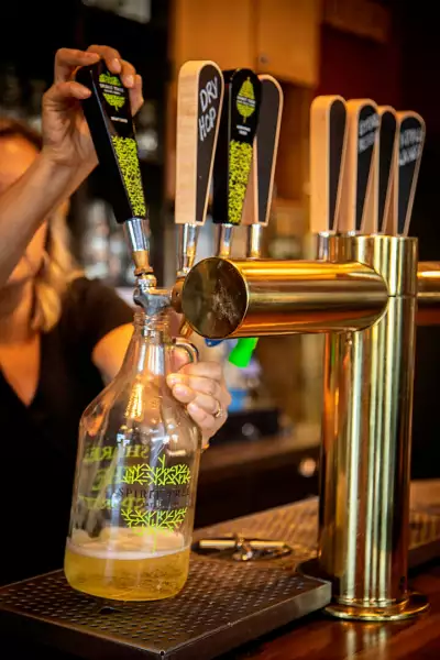 Drink ON Cider | A bartender pours a growler at Sprit Tree