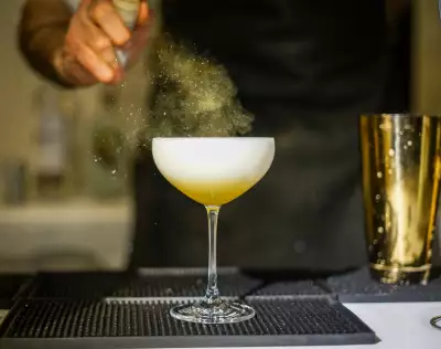Toronto Cocktail Festival | A bartender spritzes a cocktail with mist