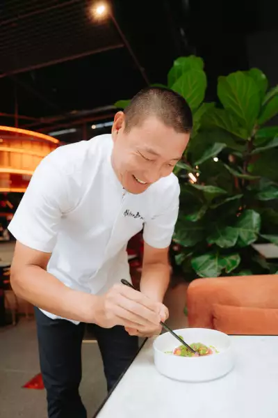 Tono by Akira Back | Chef Akira Back plates a dish at Tono by Akira Back