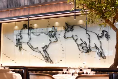 Black + Blue Steakhouse | A bull mural made entirely from steak knives displays at Black + Blue Toronto