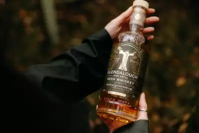 Holding a bottle of Glendalough Pot Still Irish Whiskey Holding a bottle of Glendalough Pot Still Irish Whiskey