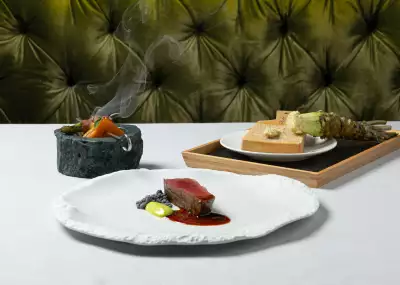 DaNico | Three dishes, including a meat plate, sit on a white tablecloth at DaNico in Little Italy