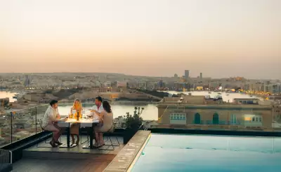 Malta's Michelin moment | A group eat al fresco on a rooftop beside a pool in Malta