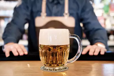 A bartender serving a glass of Pilsner Urquell A bartender serving a glass of Pilsner Urquell