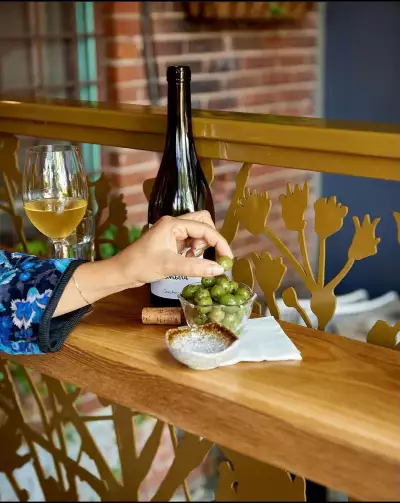 Best happy hours in Toronto | A glass of wine and olives on a ledge at Grape Witches