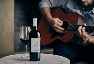 Celebrity wines | Someone playing guitar next to a bottle and glass of Z. Alexander Brown Uncaged Cabernet Sauvignon Celebrity wines | Someone playing guitar next to a bottle and glass of Z. Alexander Brown Uncaged Cabernet Sauvignon