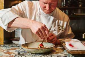 Chef Adam Ryan prepares a dish at tasting menu restaurant Azura