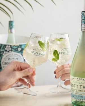 Two glasses cheers and a bottle of Croft Twist Two glasses cheers and a bottle of Croft Twist