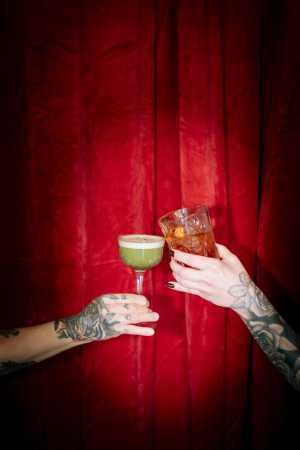 Ayla Upstairs | Cocktails clink in front of a red curtain at Ayla Upstairs Ayla Upstairs | Cocktails clink in front of a red curtain at Ayla Upstairs