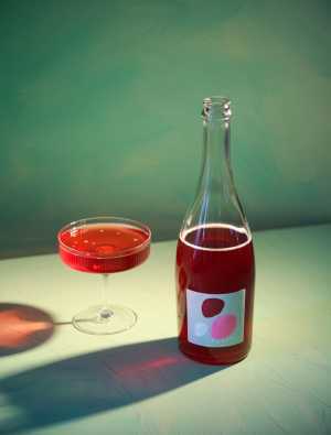 Revel Cider and Wilda team up | A bottle and glass of Revel's Soif against a green background Revel Cider and Wilda team up | A bottle and glass of Revel's Soif against a green background