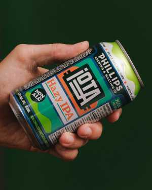 Phillips Brewing | A hand holds a can of iOTA Non-Alc Hazy IPA Phillips Brewing | A hand holds a can of iOTA Non-Alc Hazy IPA
