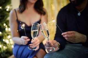 Trius Winery sparkling wine | A couple clink champagne flutes and hold sparklers in a festive setting