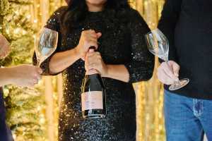 Trius Winery sparkling wine | A person in a sparkly black dress prepares to open a bottle of Trius Brut Rosé