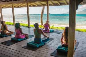 Relax in St. Kitts | A yoga class takes place in front of the ocean in St. Kitts