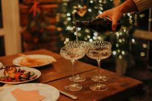 Sparkling wine | A hand pours prosecco into glasses in a festive scene at home