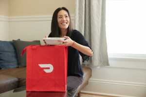 Neighbourhood Gems on DoorDash | A woman receives her DoorDash delivery at home