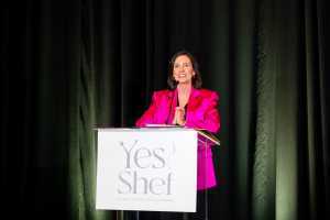 Yes Shef | A woman in a bright pink jacket presents at a Yes Shef event