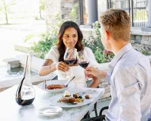 Trius Winery | A couple clink glasses on the patio at Trius Winery Restaurant