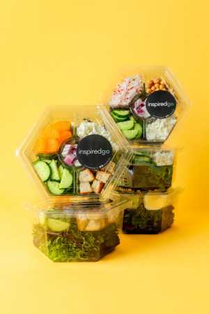 Inspired Go salads | Stacks of ready-to-eat salads from Inspired Go in front of a yellow background Inspired Go salads | Stacks of ready-to-eat salads from Inspired Go in front of a yellow background