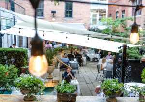 George Restaurant | A view between the twinkling lights of diner on the courtyard patio at George Restaurant