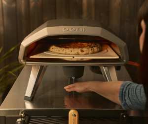 Someone uses their hand to activate the Ooni Koda 2 Pro Rotating Stone and Oven