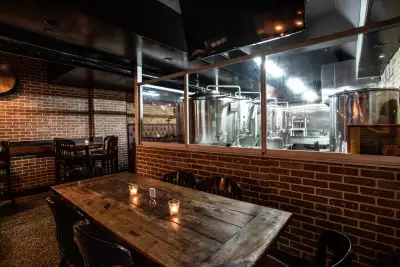 Happy hours in Toronto | A table with a view of the brewery tanks at Folly Brewpub