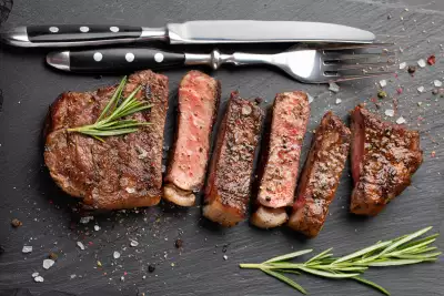 Is salt bad for you? | Closeup of a ready to eat steak with herbs, salt, garlic and butter on a stone Board