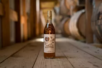 A bottle of Yellowstone Select Kentucky Straight Bourbon Whiskey in a room full of barrels