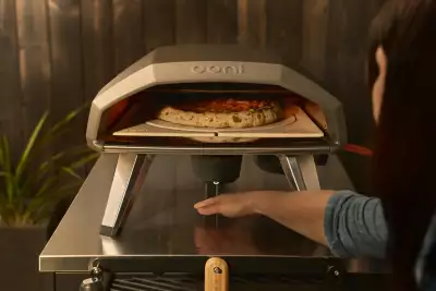 Someone uses their hand to activate the Ooni Koda 2 Pro Rotating Stone and Oven
