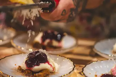 Farm-to-table dining in Qu&eacute;bec: A hand shaves cheese over a dish at La Ferme du Mihouli et Buvette de la barbotte
