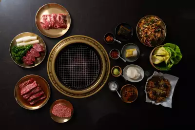 Takja BBQ | An overhead shot of the setup at Takja BBQ, featuring kalbi, vegetables, kimchi and other sides