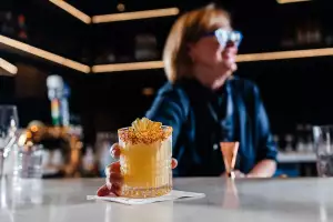 A bartender serves a cocktail inside the Aspire | Air Canada Café at Billy Bishop Toronto City Airport