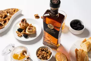 Rabbit Hole Kentucky bourbon on a table with nuts, blackberries, honey and bread Rabbit Hole Kentucky bourbon on a table with nuts, blackberries, honey and bread
