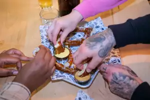 Left Field Brewery, Liberty Village, Toronto | Hands tearing apart a pretzel at Left Field Brewery Left Field Brewery, Liberty Village, Toronto | Hands tearing apart a pretzel at Left Field Brewery