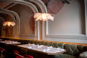 La Plume Toronto | Banquettes under floral chandeliers and a curving ceiling at La Plume in The Well La Plume Toronto | Banquettes under floral chandeliers and a curving ceiling at La Plume in The Well
