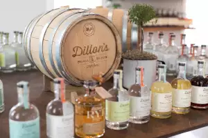 Ontario distilleries and alcohol stores | Dillon's lineup of spirits in front of a barrel