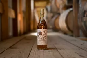 A bottle of Yellowstone Select Kentucky Straight Bourbon Whiskey in a room full of barrels A bottle of Yellowstone Select Kentucky Straight Bourbon Whiskey in a room full of barrels