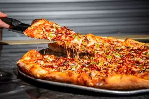 Toronto pizza | Lifting a slice from a Windsor-style pizza at Ambassador Pizza Co.