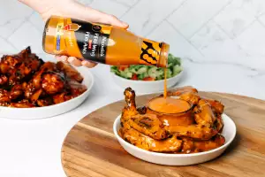Pouring Nando's Buffalo PERi Wing Sauce