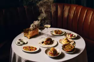 Best new Toronto restaurants | A shot of a table at Punch, featuring Beef Wellington, Scotch Egg and Mumbai Chat-Slaw