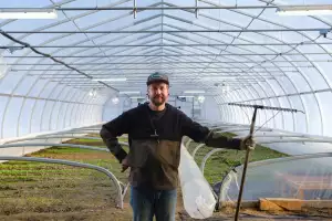 Farm-to-table dining in Qu&eacute;bec: Owner and gardener-mara&icirc;cher Jean-Martin Fortier poses inside the greenhouse at Espace Old Mill