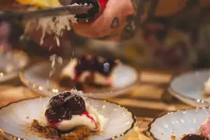 Farm-to-table dining in Qu&eacute;bec: A hand shaves cheese over a dish at La Ferme du Mihouli et Buvette de la barbotte