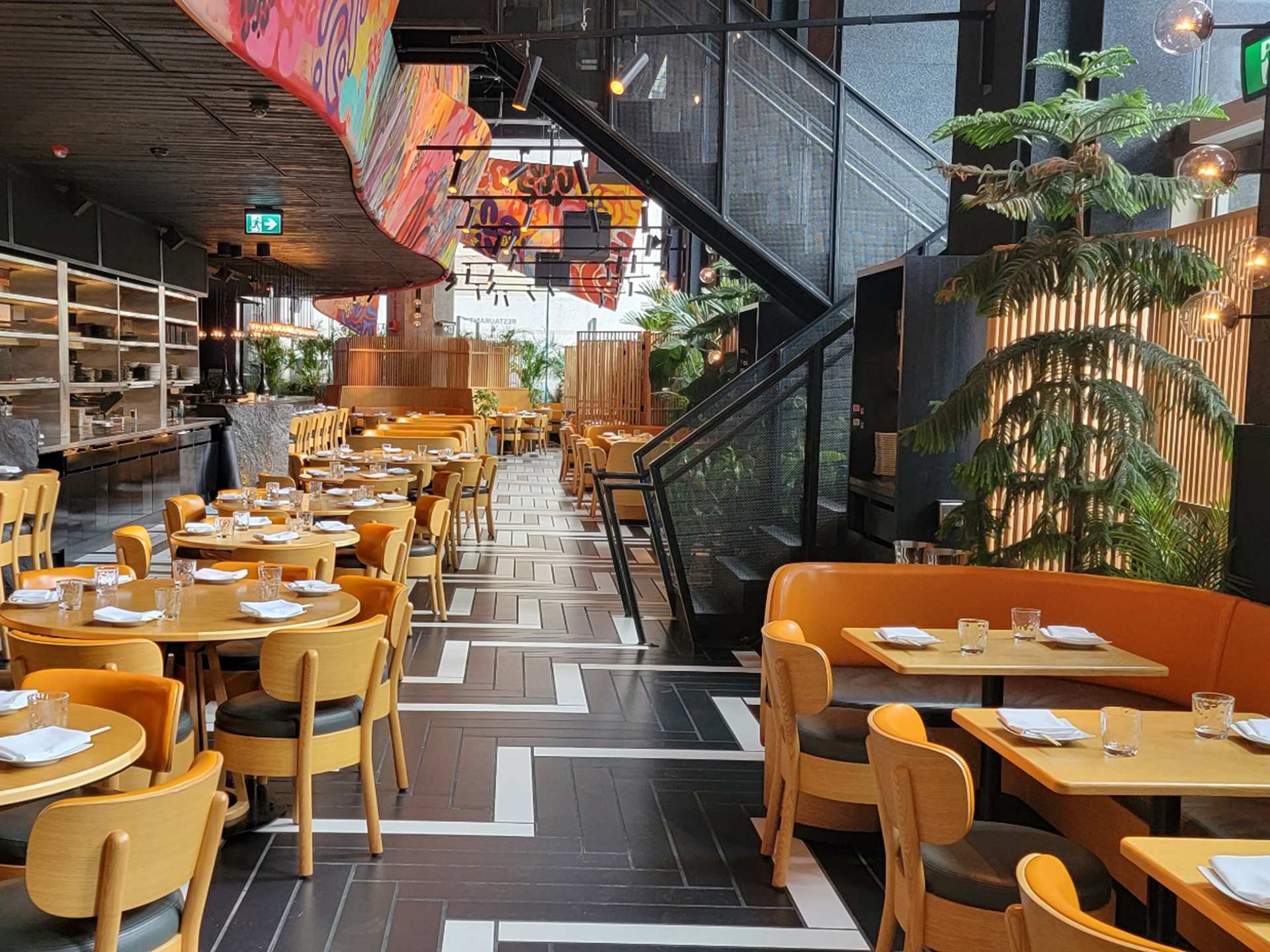 Chotto Matte | The dining room at Chotto Matte with chairs and greenery Chotto Matte | The dining room at Chotto Matte with chairs and greenery