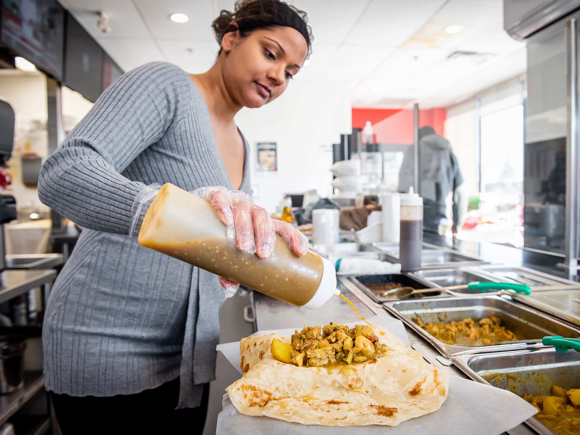 Best Scarborough restaurants | Final touches on a roti wrap at Mona's Roti