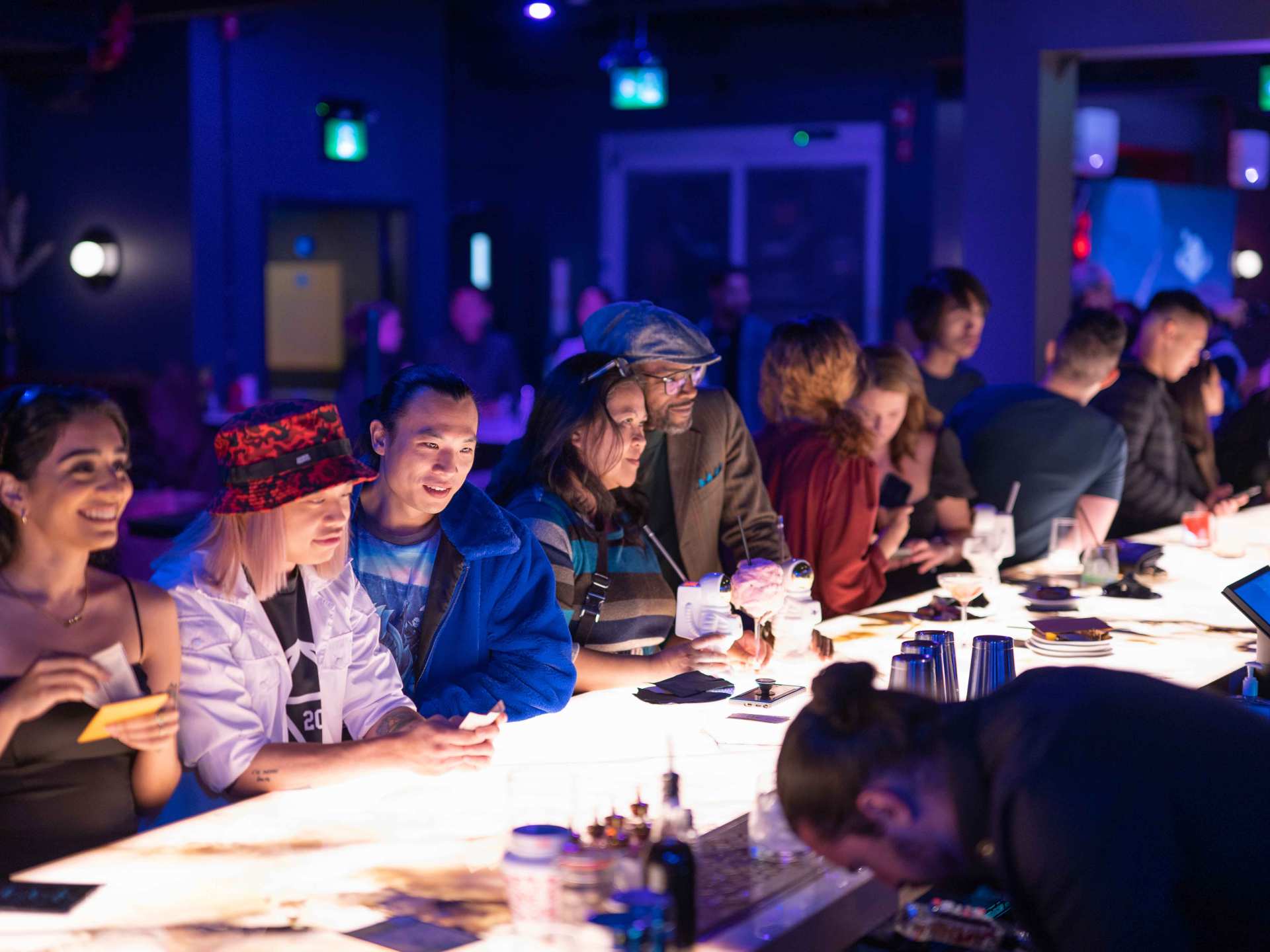 Happy Hour Toronto | Guests leaning over the bar at Offworld for happy hour