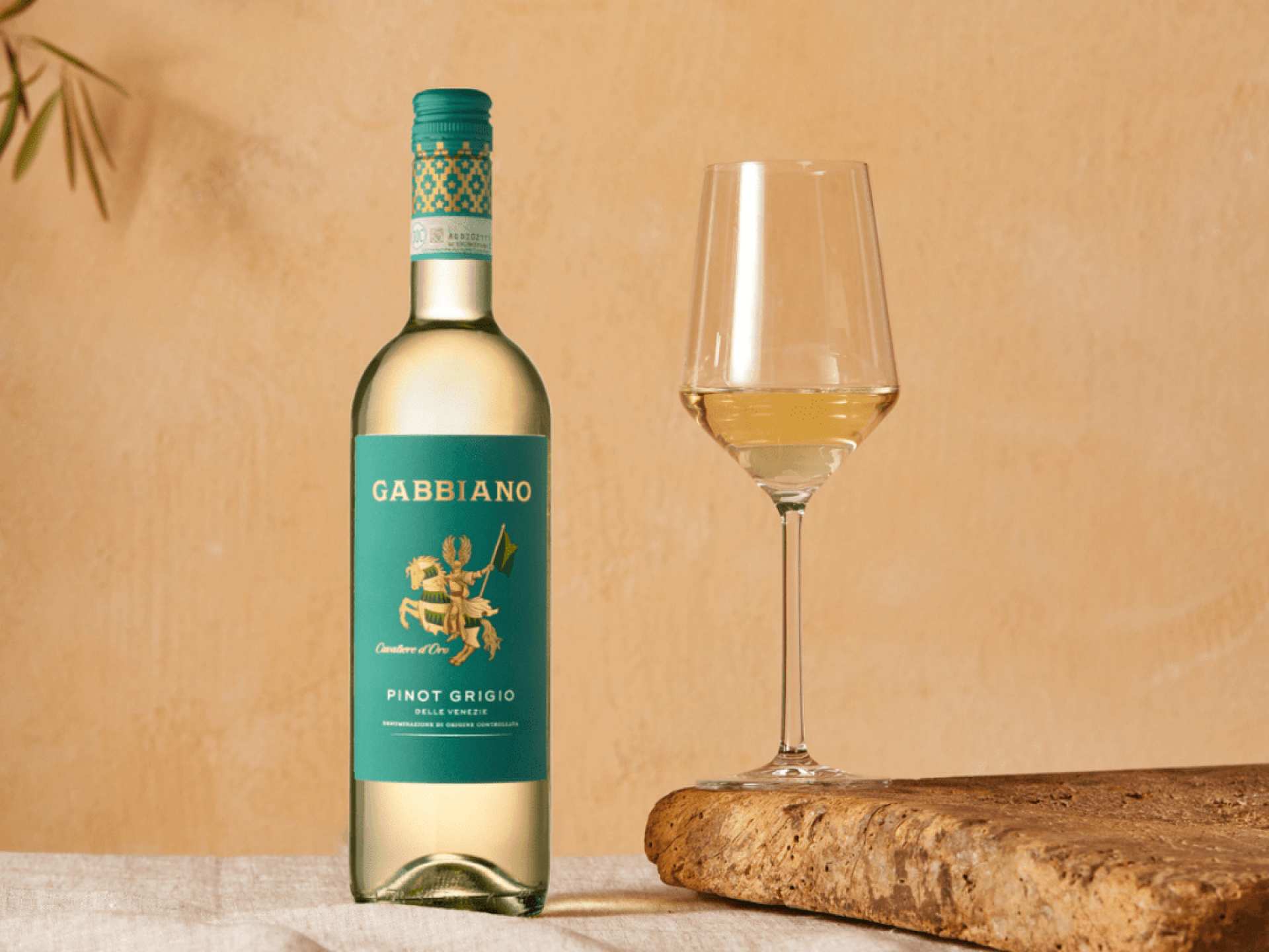 A bottle of Gabbiano Pinot Grigio IGT beside a glass of white wine A bottle of Gabbiano Pinot Grigio IGT beside a glass of white wine