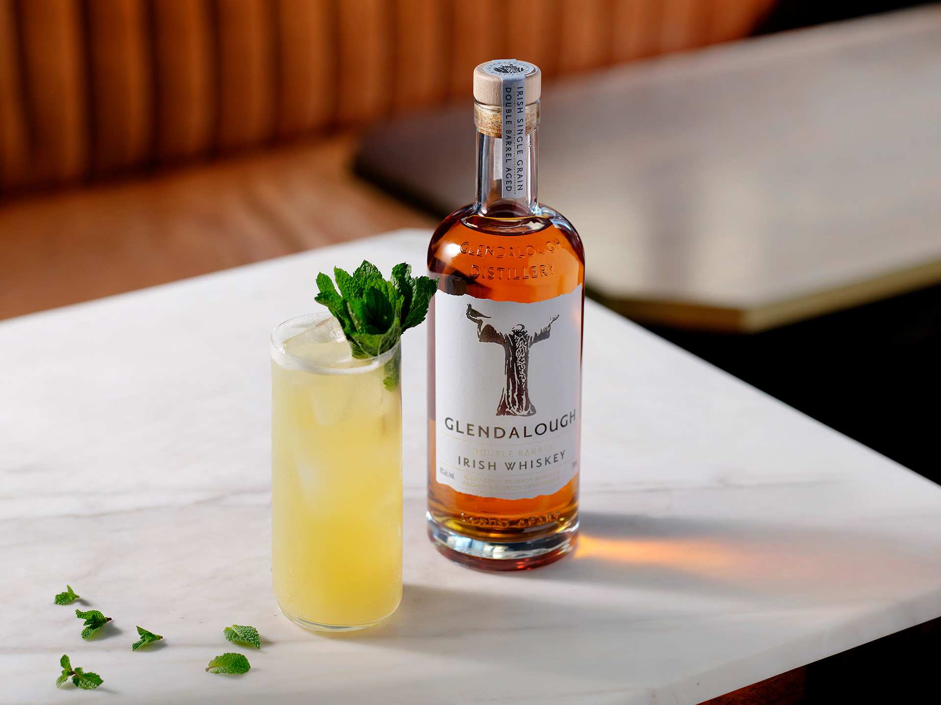 A bottle of Glendalough Double Barrel Irish Whiskey with a yellow cocktail