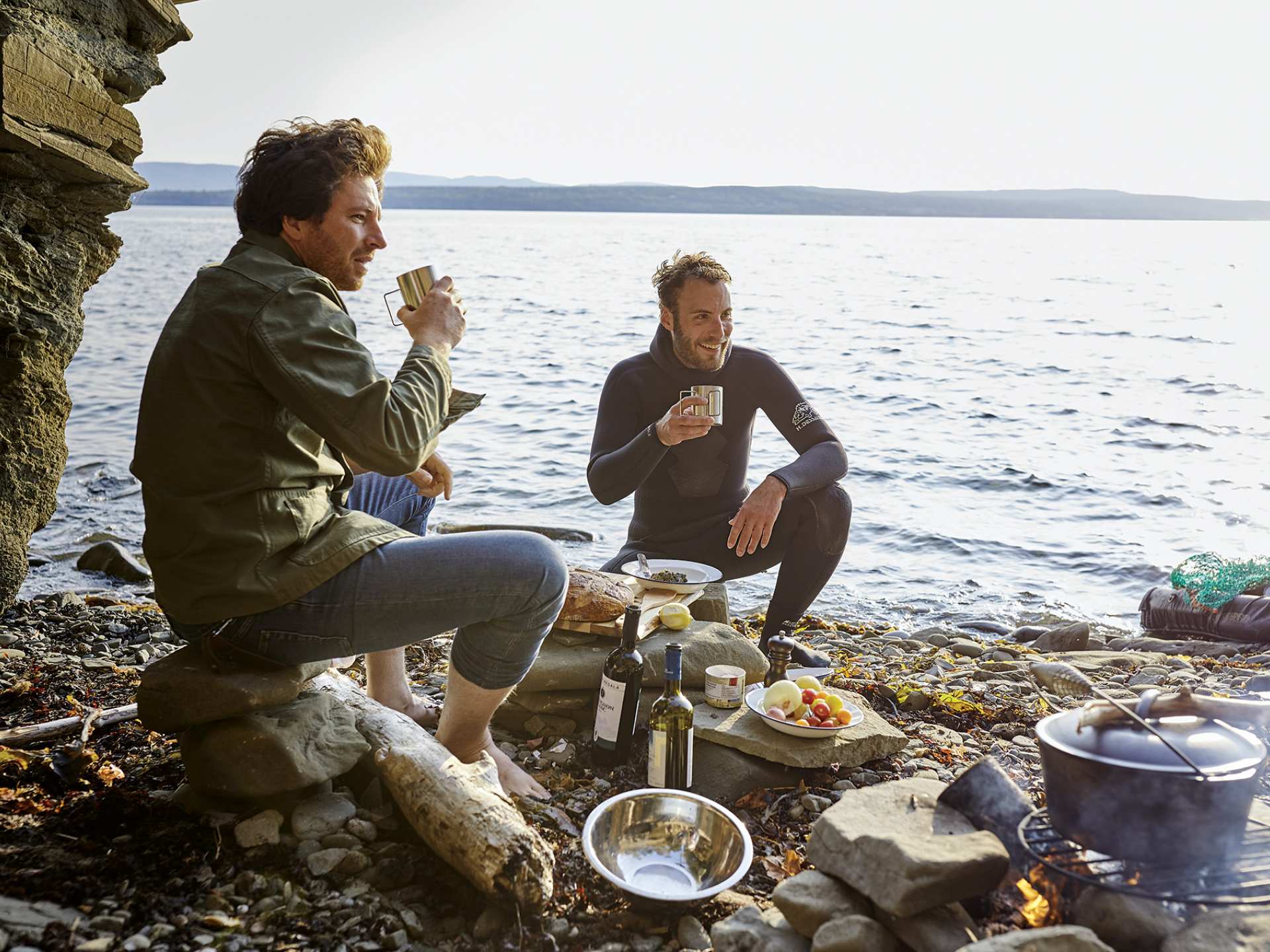 Two men enjoying a seafood boil and wine by the ocean Two men enjoying a seafood boil and wine by the ocean